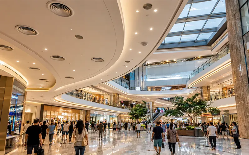 Atrio moderno de un centro comercial con ventilación HVAC en una zona de alta ocupación.
