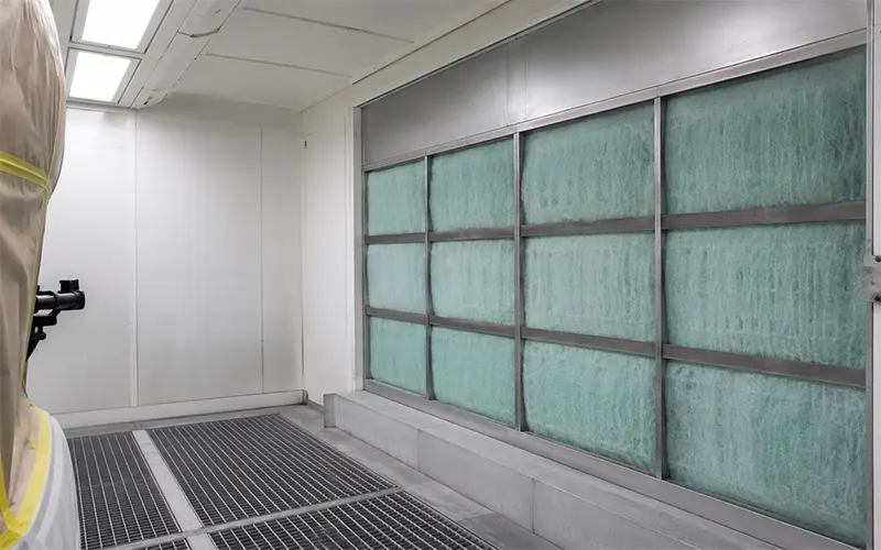 Filtro arrestador de pintura de fibra de vidrio instalado en la sección de extracción de una cabina de pintura.
