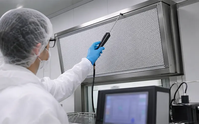 Técnico realizando un ensayo de escaneo en un filtro HEPA para detectar posibles fugas.