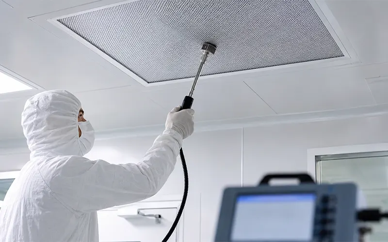 Técnico de sala limpia realizando una prueba de integridad en filtros HEPA y ULPA de techo.
