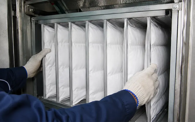 Instalación de un filtro de bolsa en un sistema HVAC industrial.