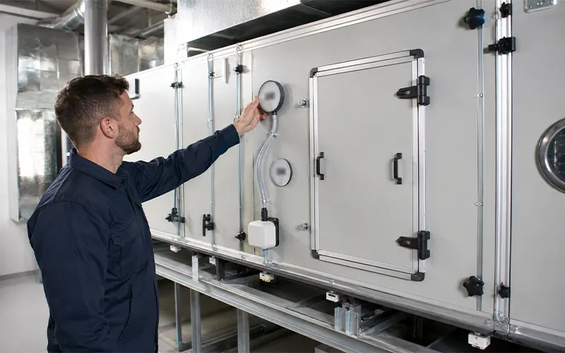 Técnico comprobando la caída de presión en un sistema HVAC mediante un manómetro diferencial.